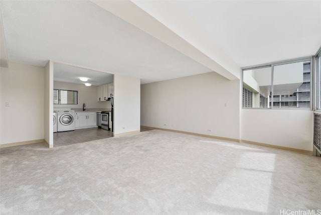 unfurnished living room featuring washing machine and dryer and carpet flooring