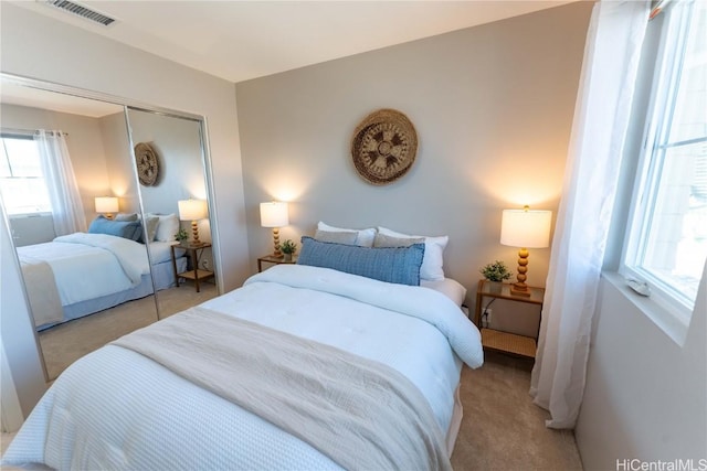 bedroom featuring light colored carpet and a closet