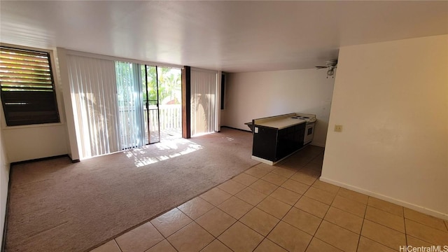 empty room with ceiling fan and light carpet