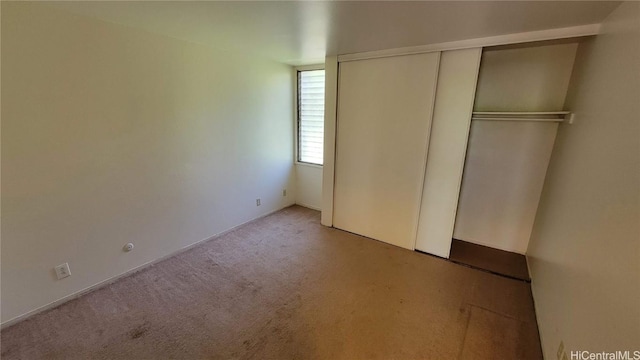 unfurnished bedroom featuring carpet flooring and a closet