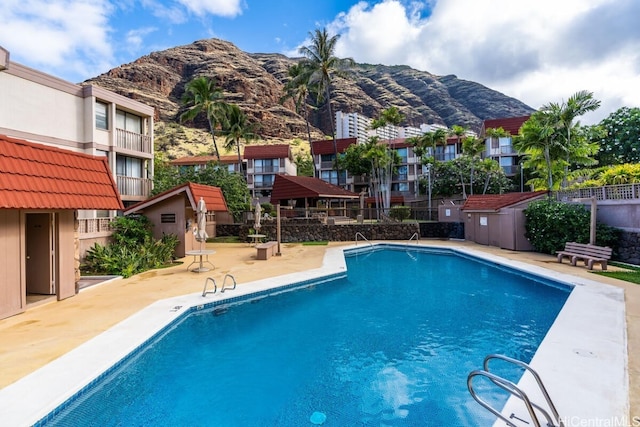 view of swimming pool with a mountain view and a patio