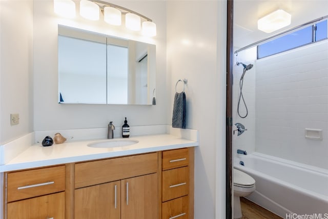 full bathroom with vanity, wood-type flooring, tiled shower / bath combo, and toilet