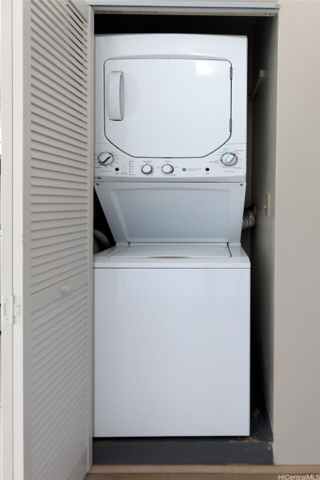 washroom featuring stacked washer / drying machine and laundry area