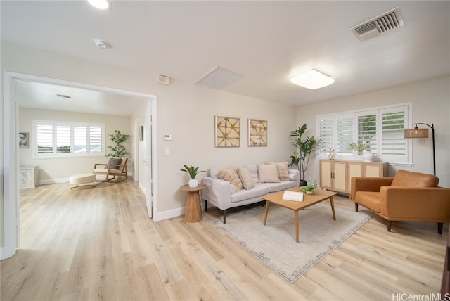 living room with a healthy amount of sunlight and light hardwood / wood-style floors