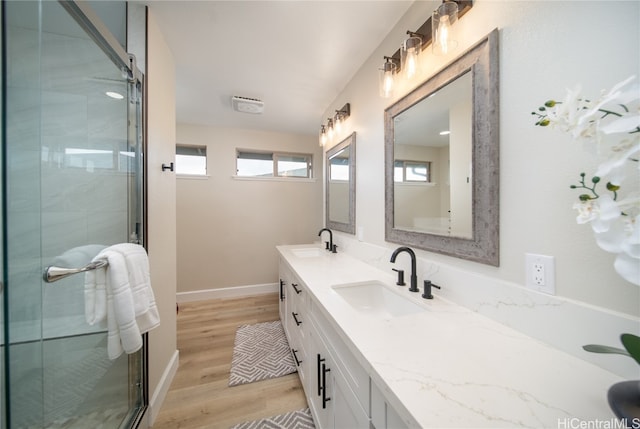 bathroom with hardwood / wood-style floors, vanity, and a shower with shower door