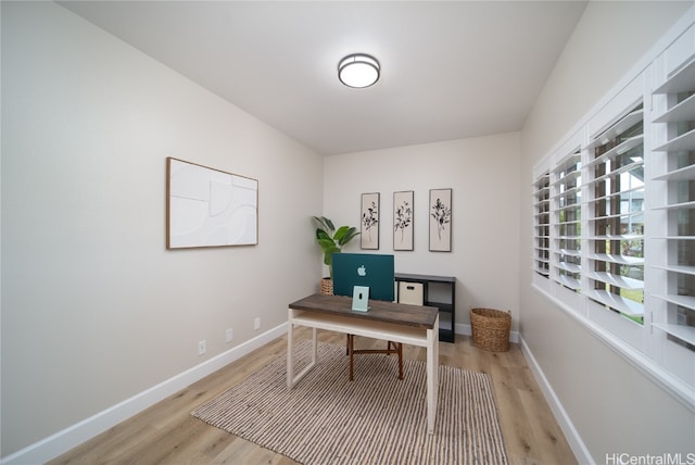 home office with light hardwood / wood-style flooring