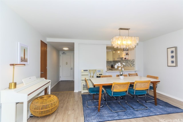 dining room with a notable chandelier and light wood-type flooring