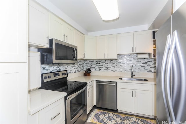 kitchen with white cabinetry, backsplash, stainless steel appliances, and sink