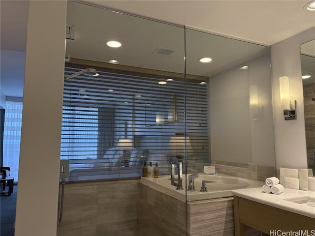 bathroom with vanity and shower with separate bathtub