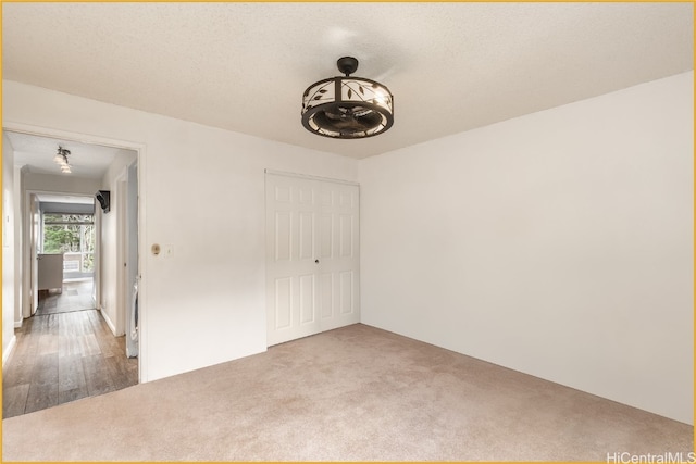 carpeted empty room with a textured ceiling