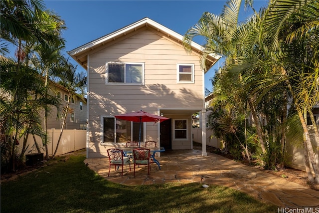 back of house with a patio area and a lawn