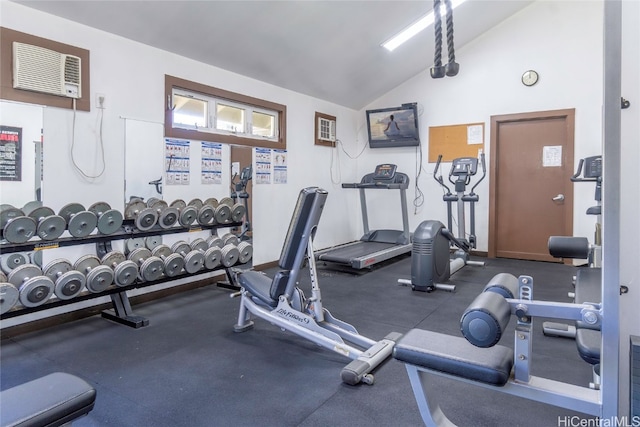 exercise room featuring an AC wall unit and lofted ceiling