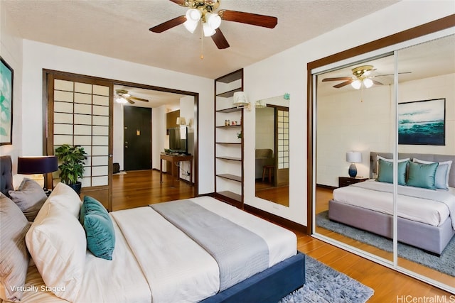 bedroom with hardwood / wood-style floors, ceiling fan, a textured ceiling, and a closet