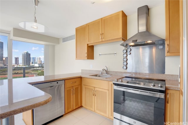 kitchen with wall chimney range hood, light tile patterned floors, light brown cabinetry, sink, and stainless steel appliances