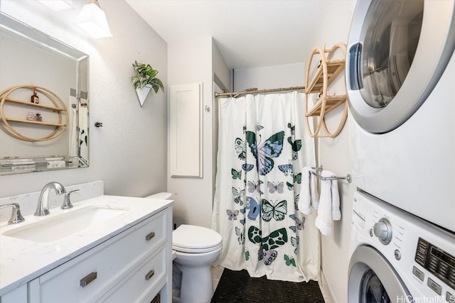 bathroom with vanity, curtained shower, toilet, and stacked washer and dryer