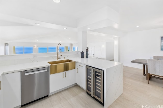 kitchen featuring white cabinetry, wine cooler, stainless steel dishwasher, kitchen peninsula, and light hardwood / wood-style floors