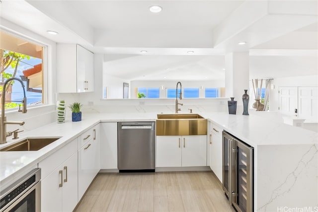 kitchen with kitchen peninsula, dishwasher, wine cooler, and sink