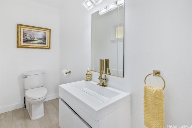 bathroom featuring vanity, hardwood / wood-style flooring, and toilet