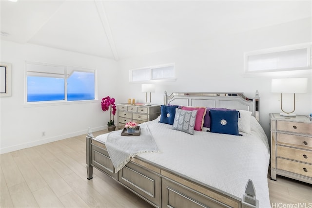 bedroom with light hardwood / wood-style floors and lofted ceiling