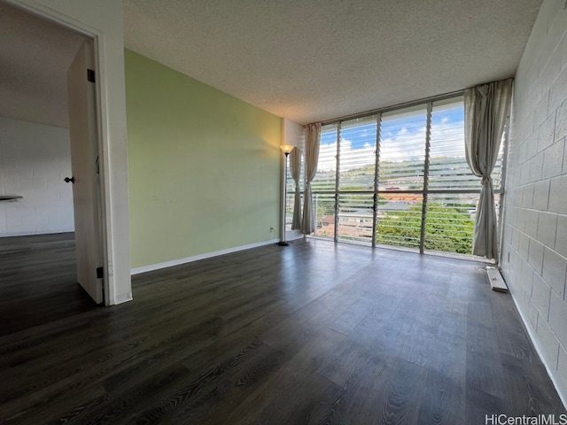 spare room featuring a textured ceiling, dark hardwood / wood-style flooring, and floor to ceiling windows