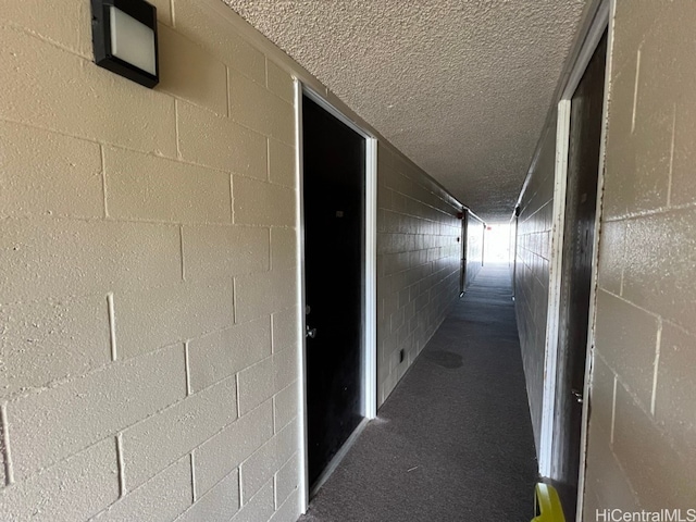 hall with carpet and a textured ceiling