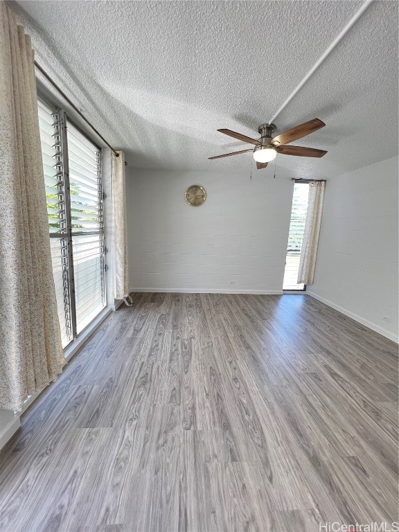 unfurnished room featuring light hardwood / wood-style flooring, a textured ceiling, and ceiling fan