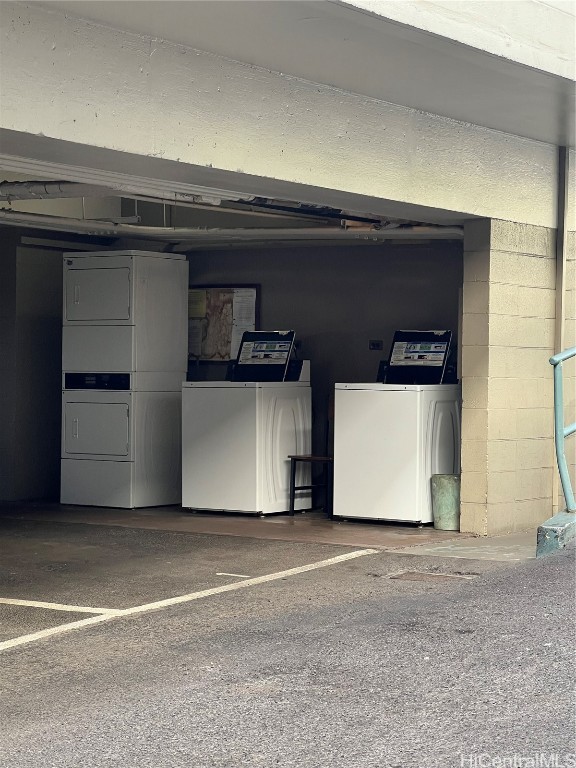 garage featuring stacked washer and dryer and washing machine and clothes dryer