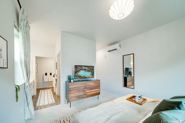 bedroom with light carpet, a wall mounted air conditioner, and ensuite bath