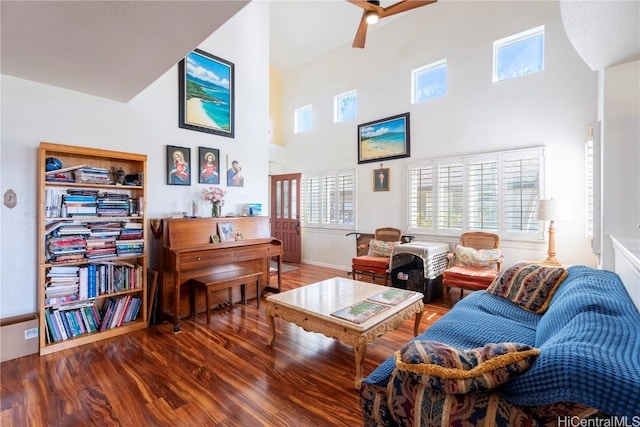 living room with hardwood / wood-style floors, a towering ceiling, and ceiling fan