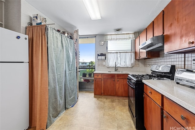 kitchen with tasteful backsplash, light tile patterned flooring, sink, black gas range oven, and white refrigerator