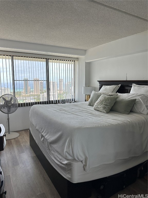 bedroom featuring hardwood / wood-style floors and a textured ceiling