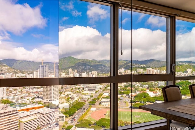 unfurnished sunroom with a view of city and a mountain view