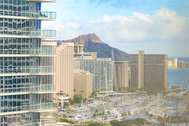 property's view of city with a water and mountain view