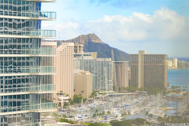 property's view of city with a water and mountain view