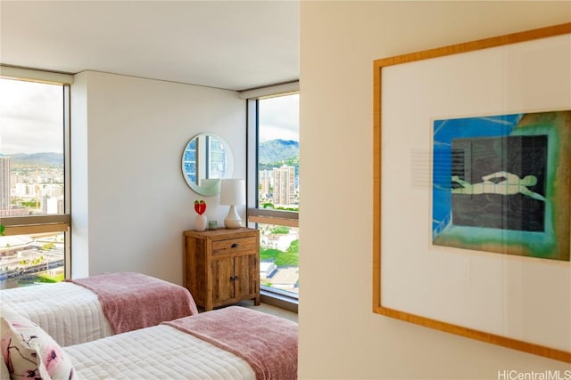 bedroom with a mountain view and a wall of windows