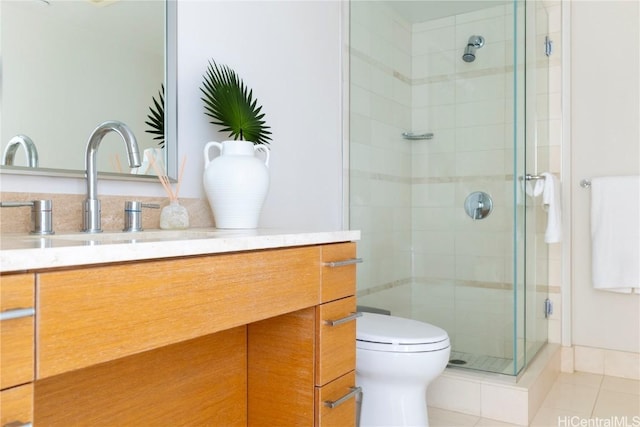 bathroom featuring toilet, a stall shower, tile patterned flooring, and vanity