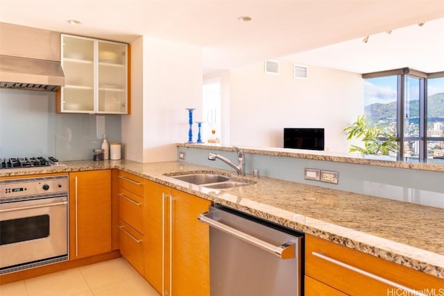 kitchen with range hood, stainless steel appliances, visible vents, glass insert cabinets, and a sink