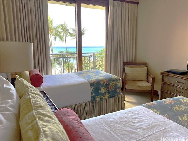 carpeted bedroom with access to exterior and a water view