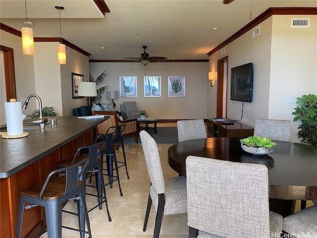 dining space featuring crown molding, light tile patterned flooring, and ceiling fan