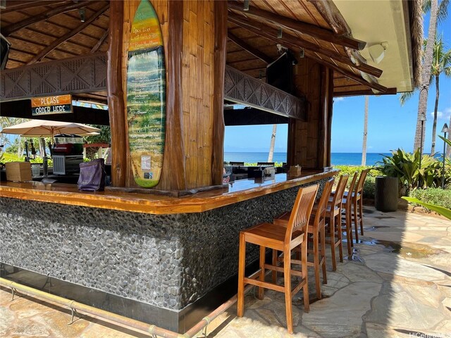 view of patio with outdoor dry bar and a water view