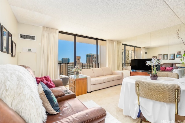 living room with light carpet, a textured ceiling, and floor to ceiling windows