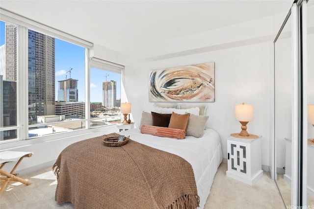 carpeted bedroom featuring a view of city and baseboards
