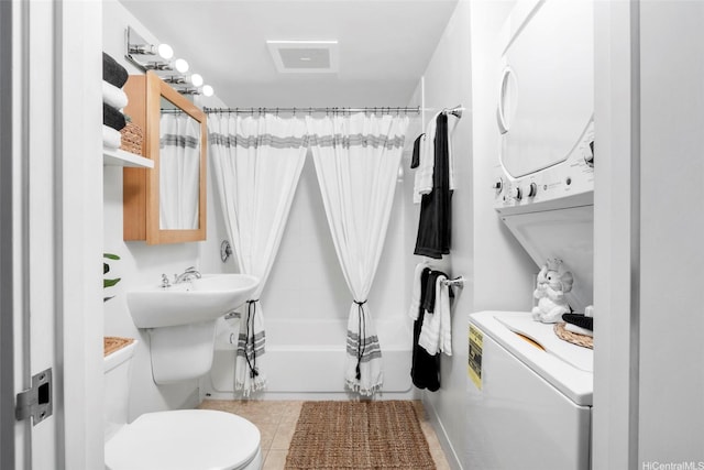 full bath featuring tile patterned floors, stacked washer / dryer, shower / tub combo, toilet, and visible vents