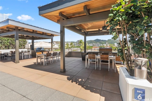 view of patio featuring a gazebo, area for grilling, a mountain view, and an outdoor kitchen