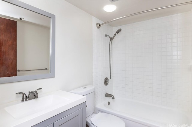 full bathroom with vanity, tiled shower / bath combo, and toilet