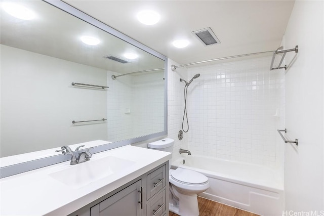 full bathroom with vanity, toilet, wood-type flooring, and tiled shower / bath