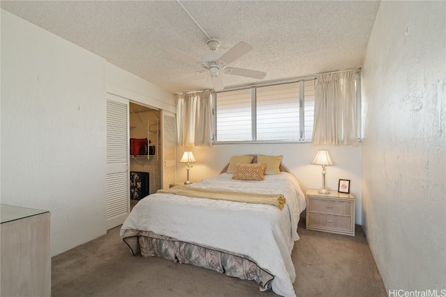 carpeted bedroom featuring ceiling fan, a textured ceiling, and a closet