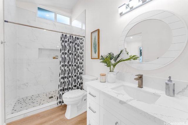 bathroom with a shower with shower curtain, hardwood / wood-style floors, vanity, and toilet