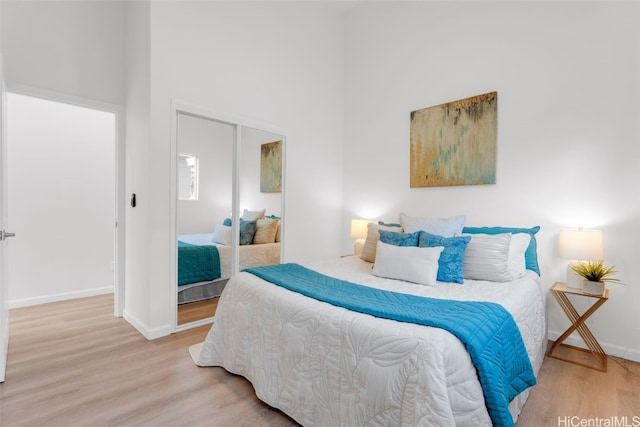 bedroom featuring a high ceiling, hardwood / wood-style flooring, and a closet