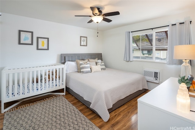 bedroom featuring an AC wall unit, dark hardwood / wood-style floors, and ceiling fan